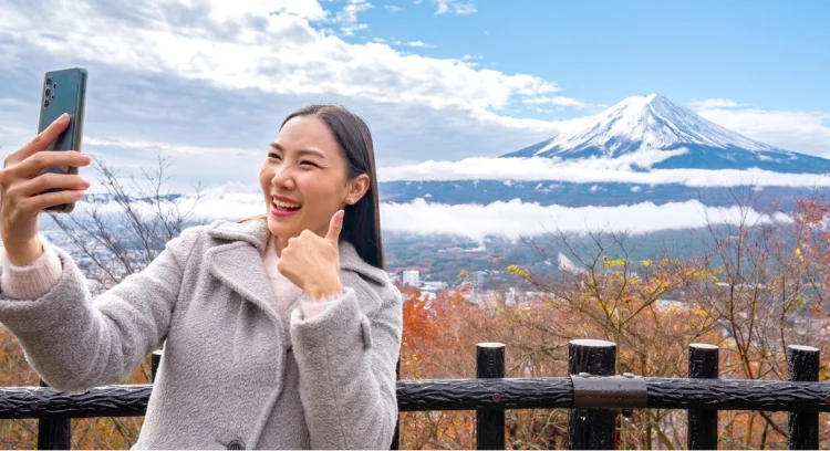 富士山を背景に記念撮影する旅行者